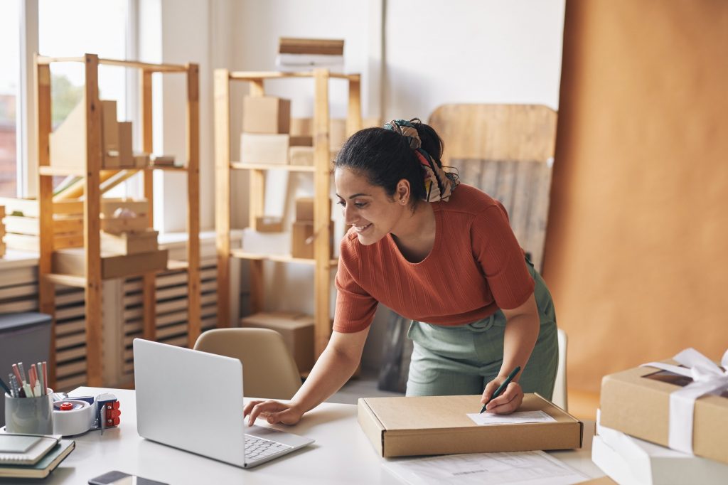 Woman completing orders by laptop